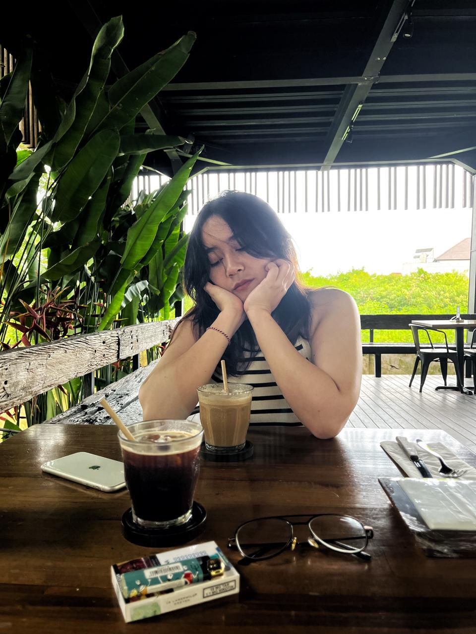 Nia resting with iced coffee on the table